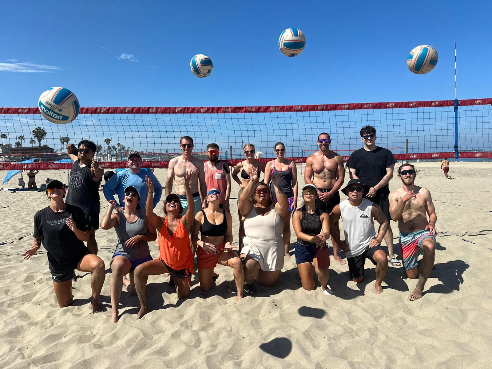 A large OBVB adult volleyball group on a sunny beach