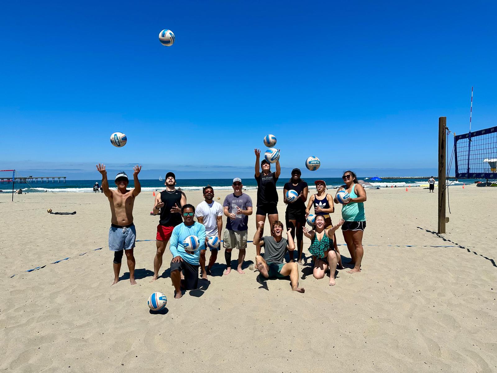 Adult beach volleyball players training beside the ocean