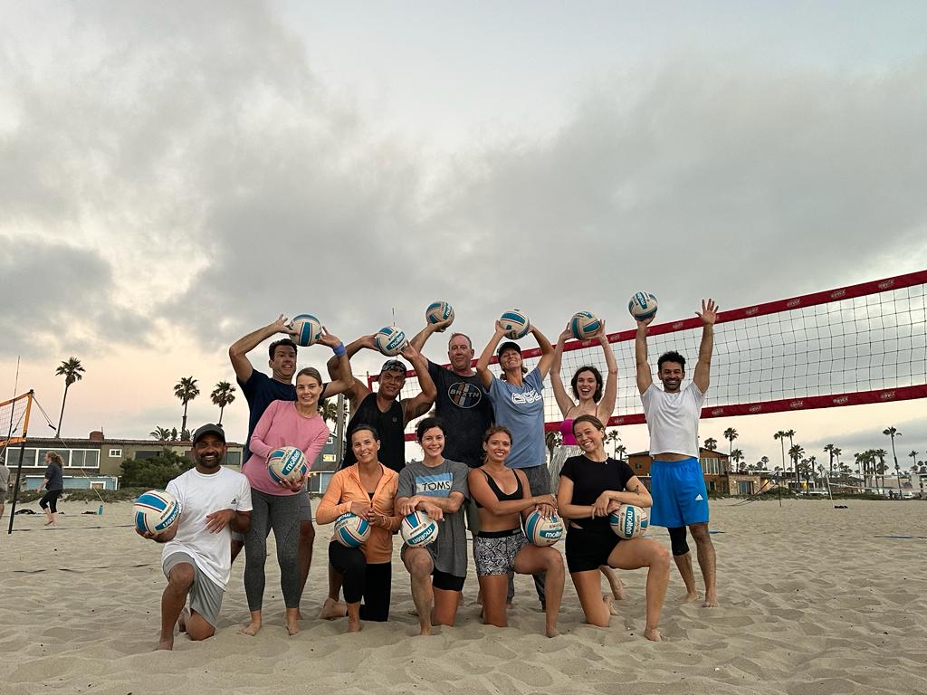 An OBVB adult group smiling together on the sand