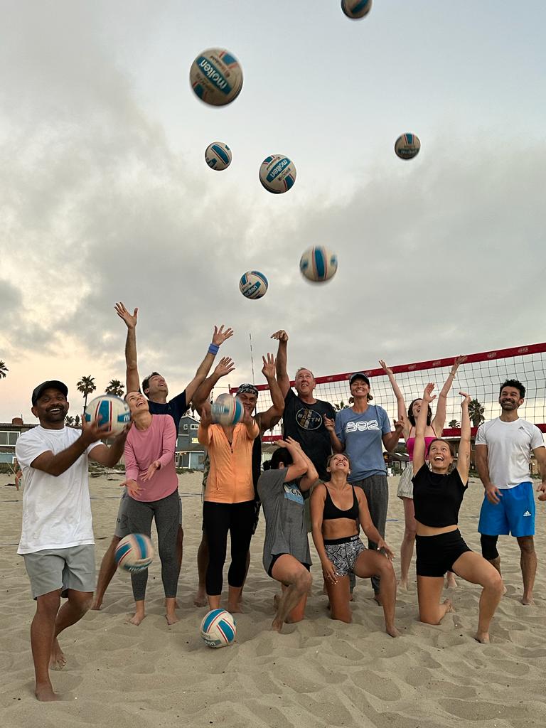 A welcoming OBVB group having fun with volleyballs on the beach